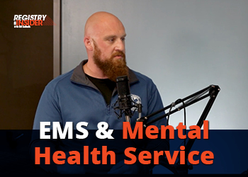 A man with a beard speaks into a microphone, discussing EMS and mental health services. The background is simple and professional.