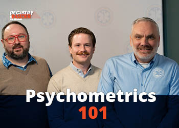 Three men stand together, smiling, with a backdrop featuring the text "Psychometrics 101." They are dressed in casual attire.