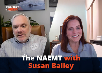 Two individuals are engaged in a video discussion about the NAEMT. One is wearing a gray shirt, and the other has long brown hair.
